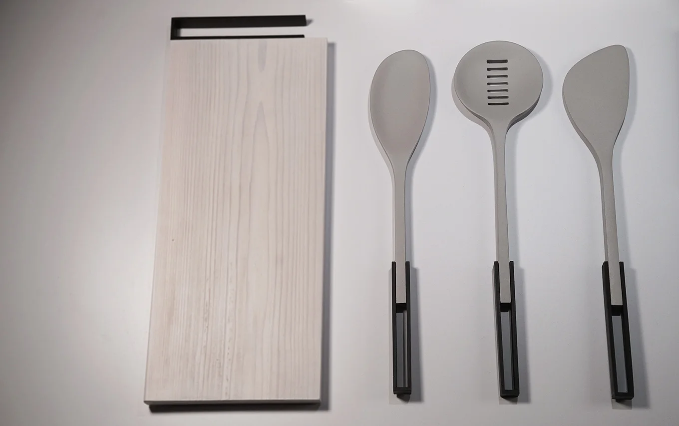 The cooking utensils include a spoon, slotted spoon, and a spatula. The organic nylon forms are attached to a metal frame handle.