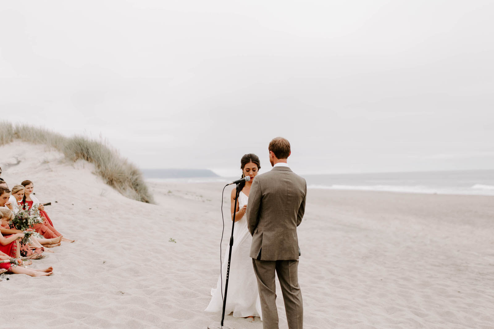 pacific city cape kiwanda community center oregon coast wedding beach feminist queer lgbtq photographer jamie carle lgbt overcast sunny harsh sun reception pink bridesmaids dresses