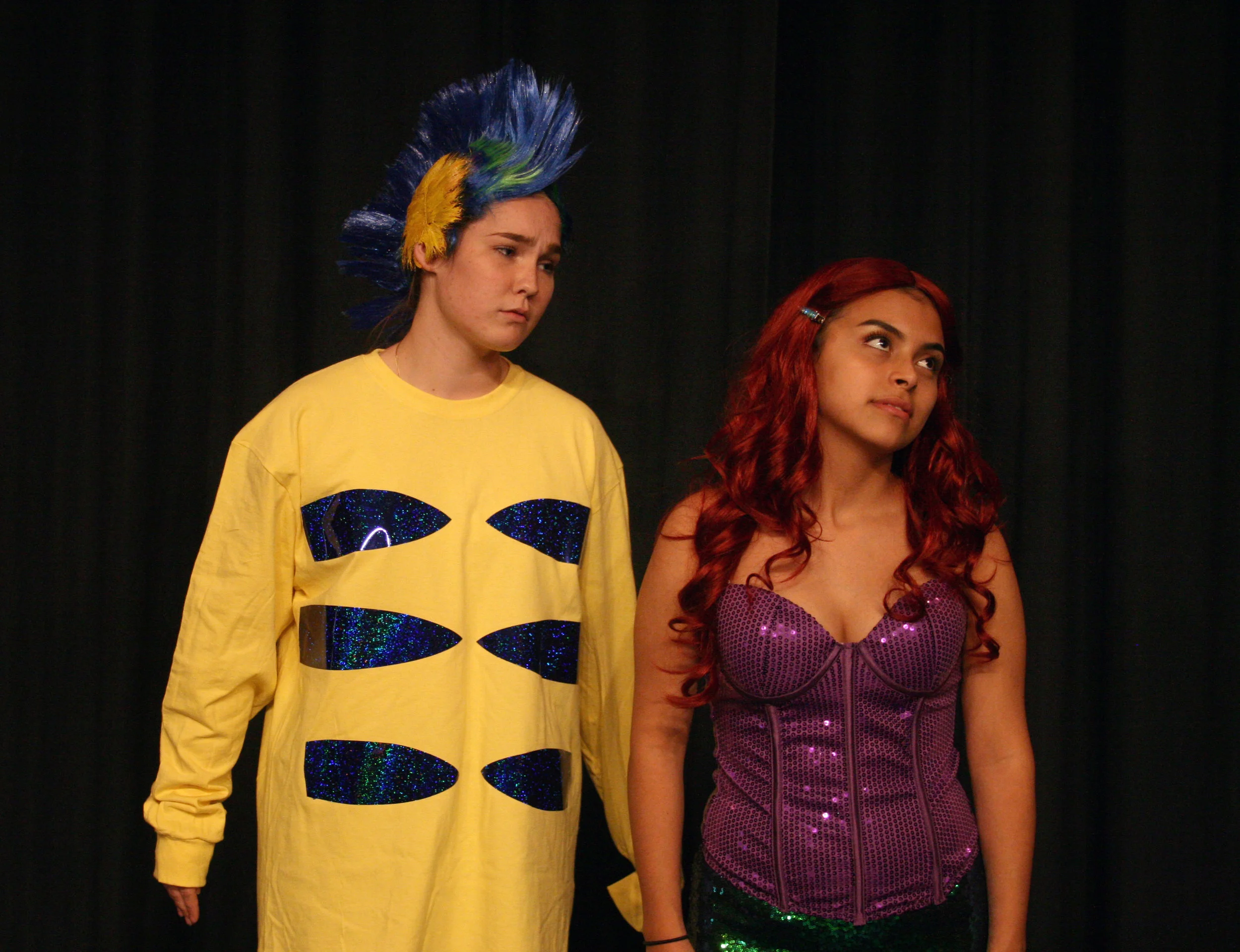 Flounder (Sydney Suits) wishes that Ariel (Jennifer Trejo Benitez) would look at him the way she looks at the human prince.
