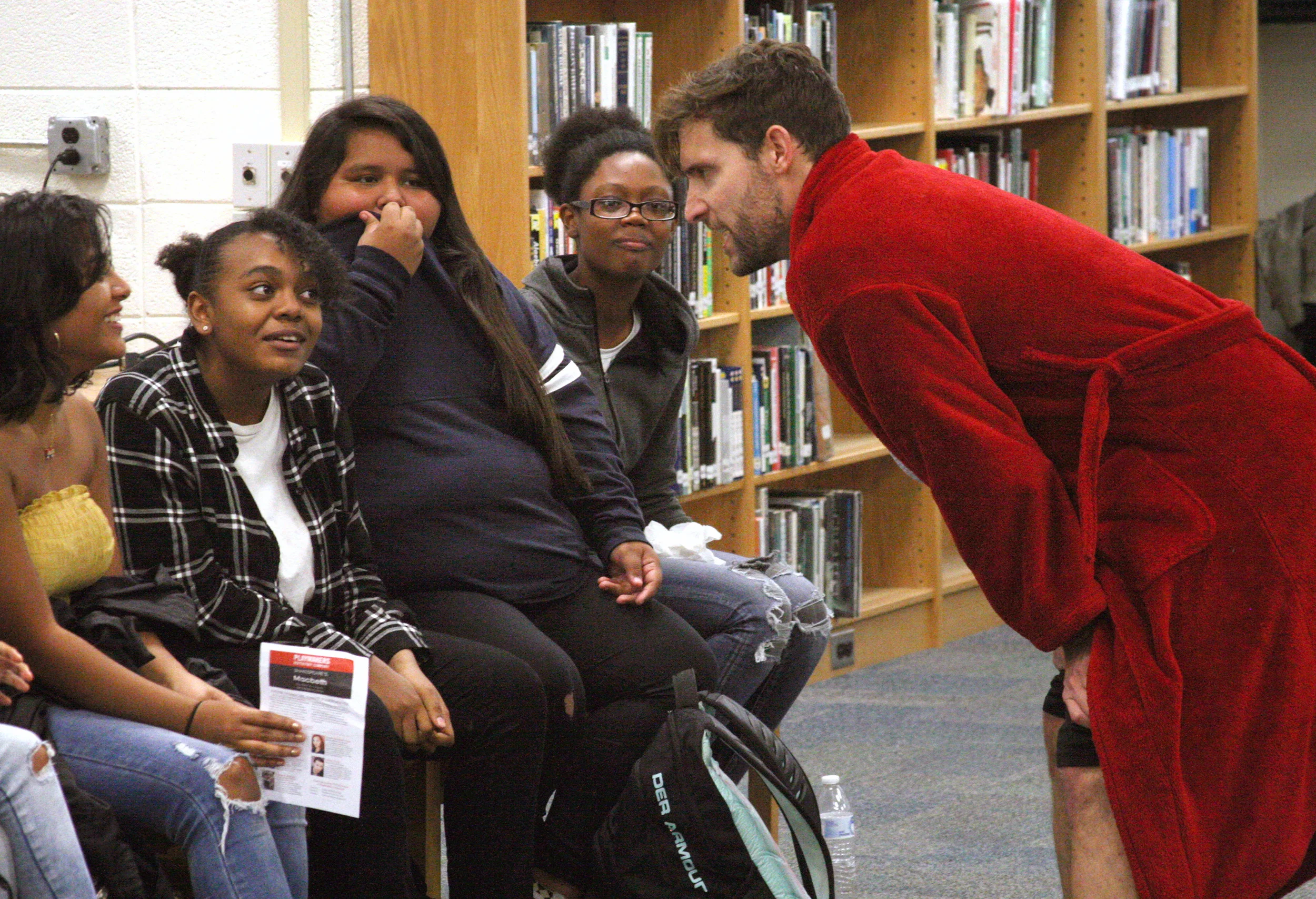 Actor Adam Poole, right, interacts with audience members during last fall’s performance of “Macbeth” in the Jordan-Matthews High School Media Center. PlayMakers Repertory Company returns on October 17 for a free performance of “Wilder & Wilder.”…