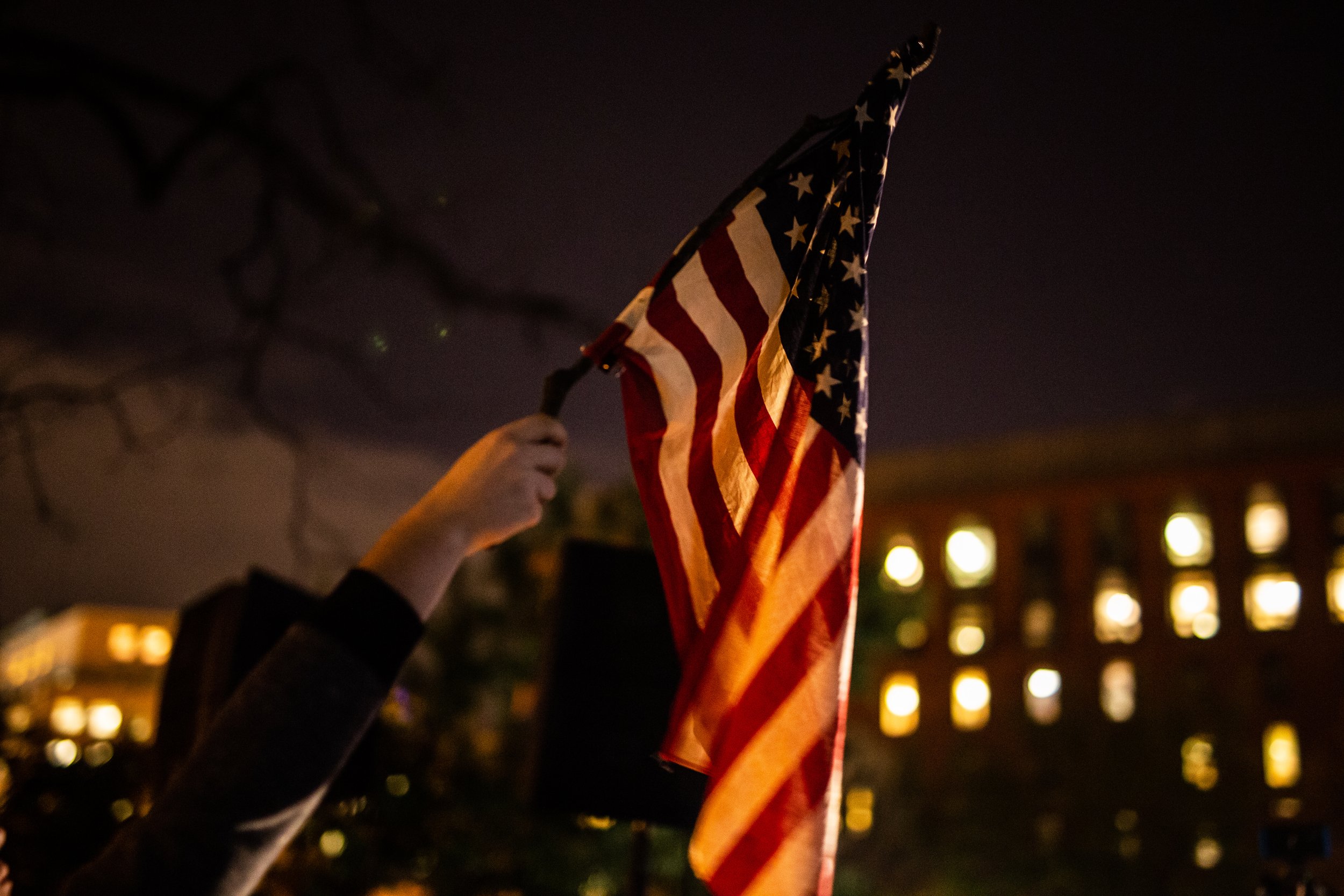  A protestor raises an American flag in Lafayette Square following the firing of then Attorney General Jeff Sessions.      November 2019   