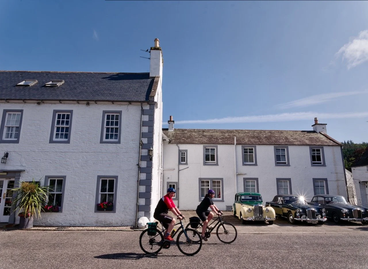 Galloway Cycling Holidays happy cyclists in front of typical Scottish houses in Gatehouse