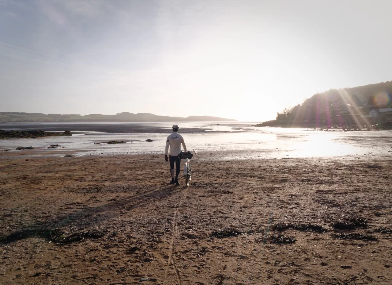 cyclist on empty beach with Gravel bike
