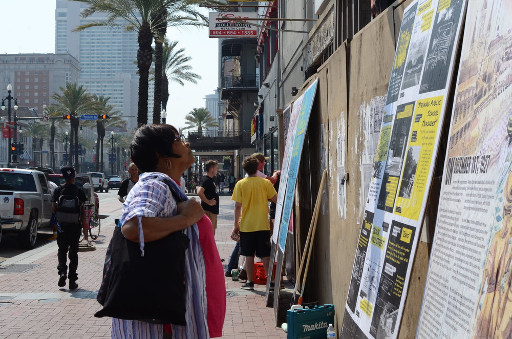  A passer-by reads installation pieces at the Canal Street site. 