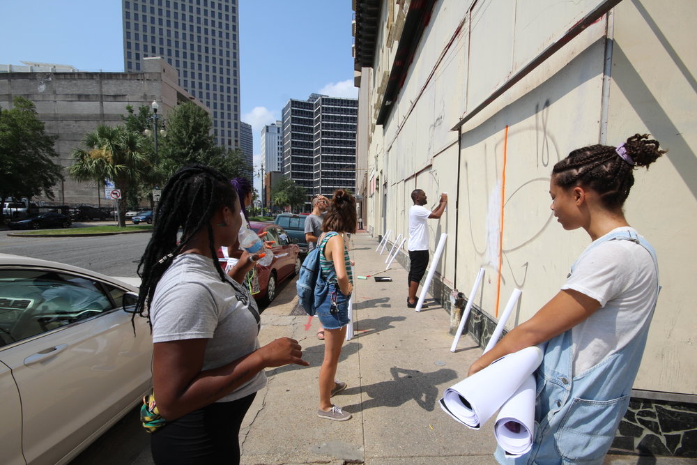  Paper Monuments volunteers Kodi and Erica install posters at the Rampart Street site.  