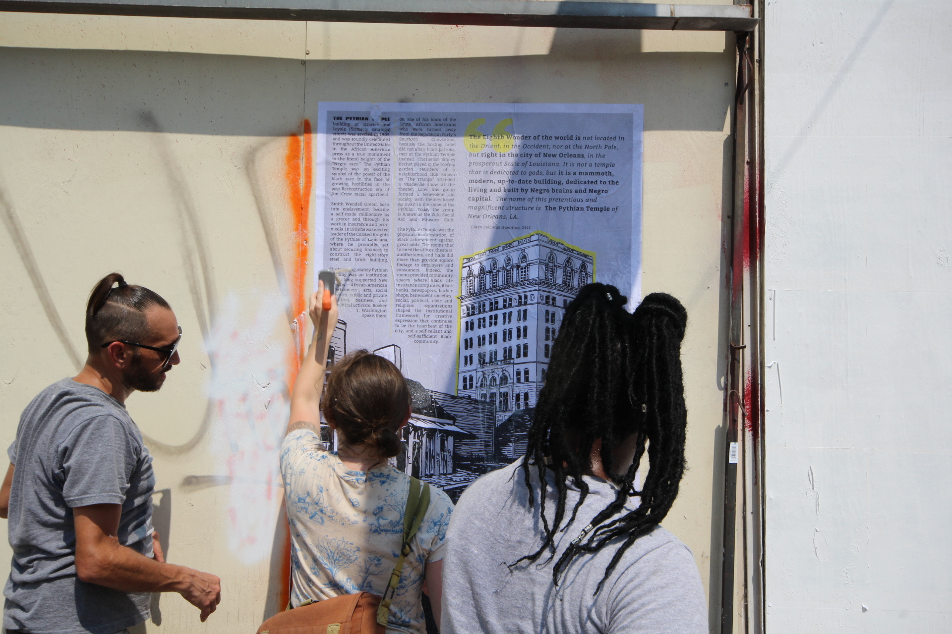  Paper Monuments volunteers Michael, Dana and Kodi install poster PMPLC #021 The Pythian Temple at the Rampart Street site. 