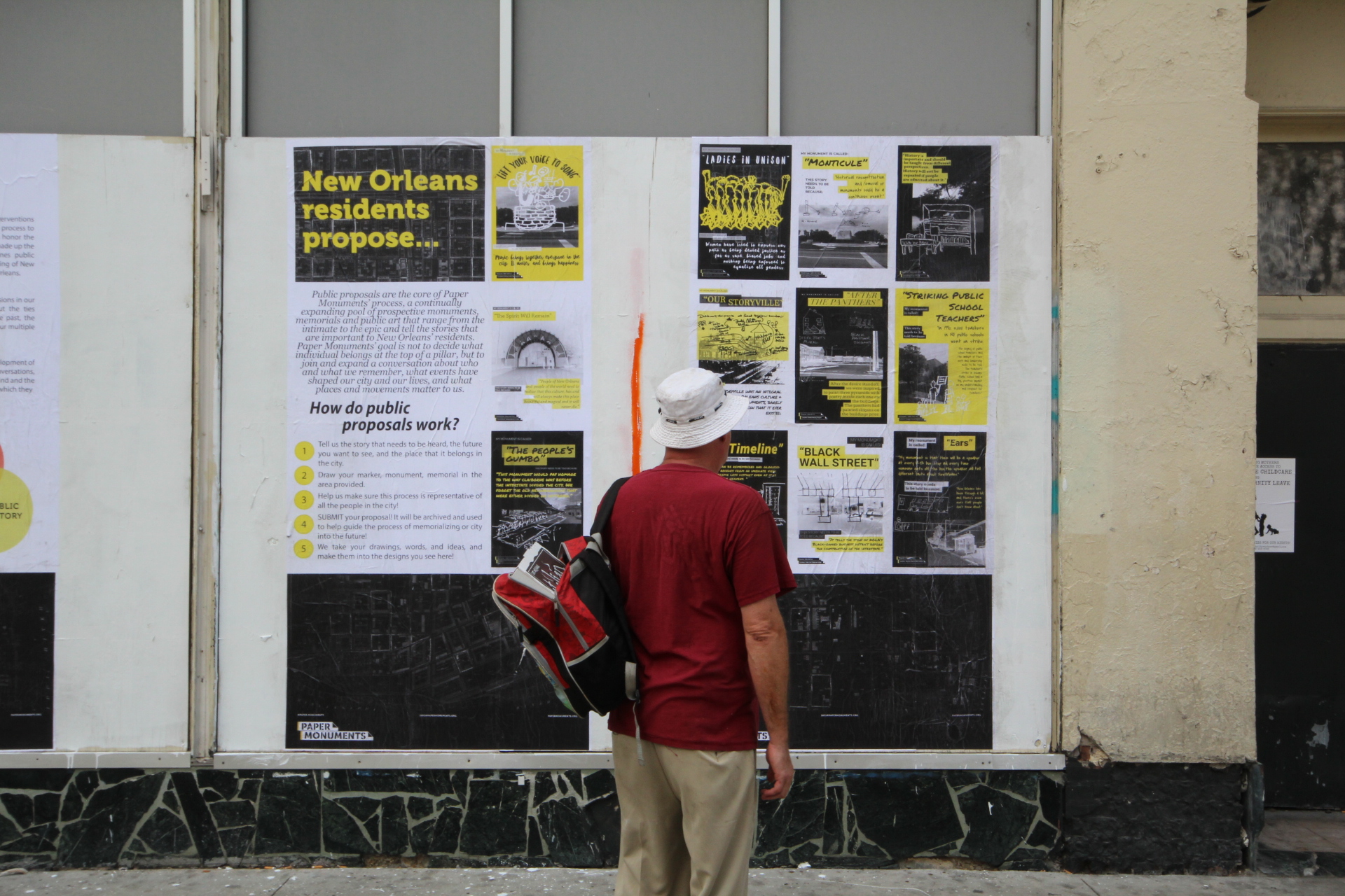  A passer-by reads Public Proposal panels at the Rampart Street site.  