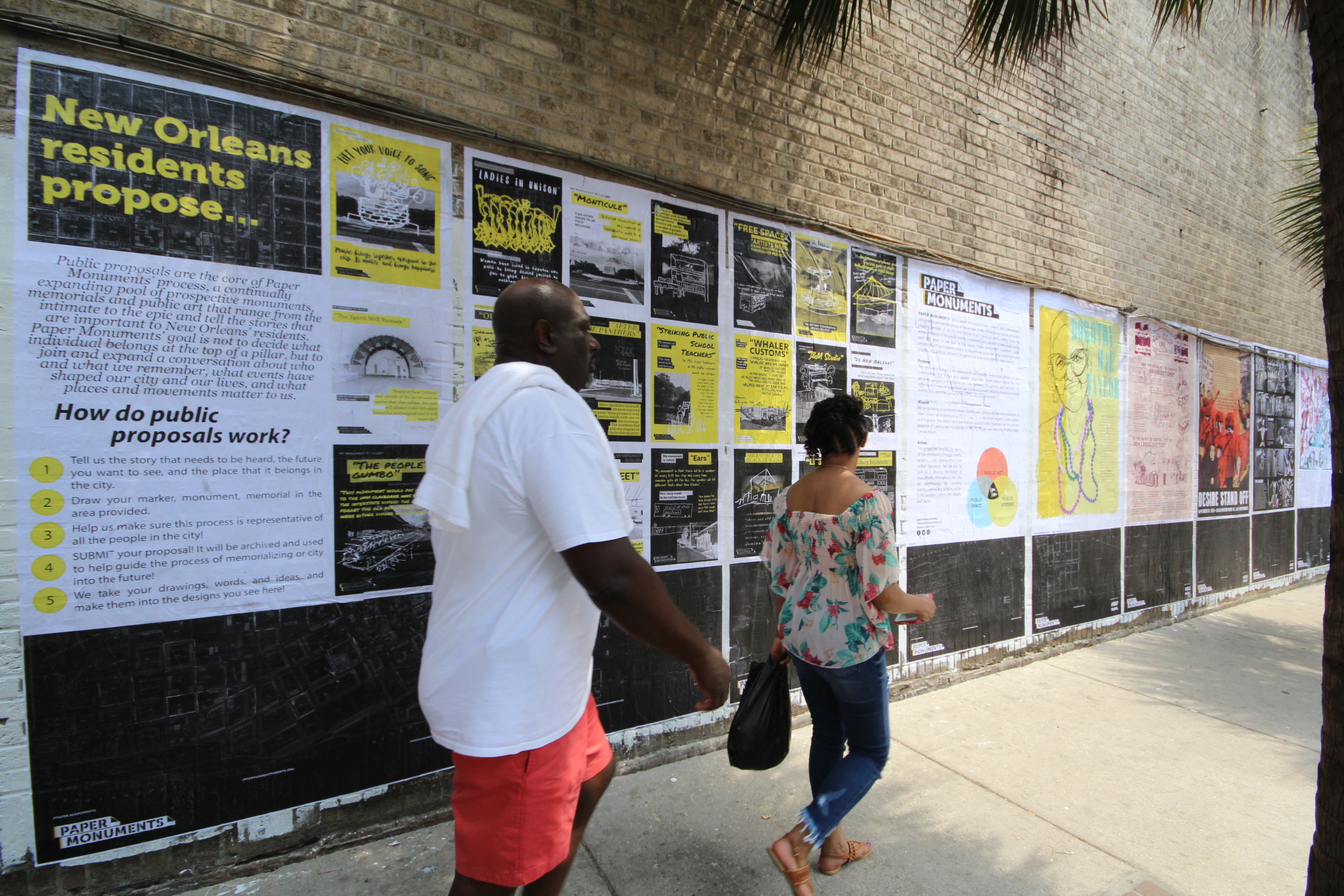  Passers-by read Public Proposal panels at the Elk Place site.  