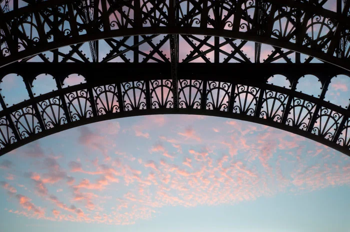 Paris pictures, section of Eiffel Tower against a pink sky