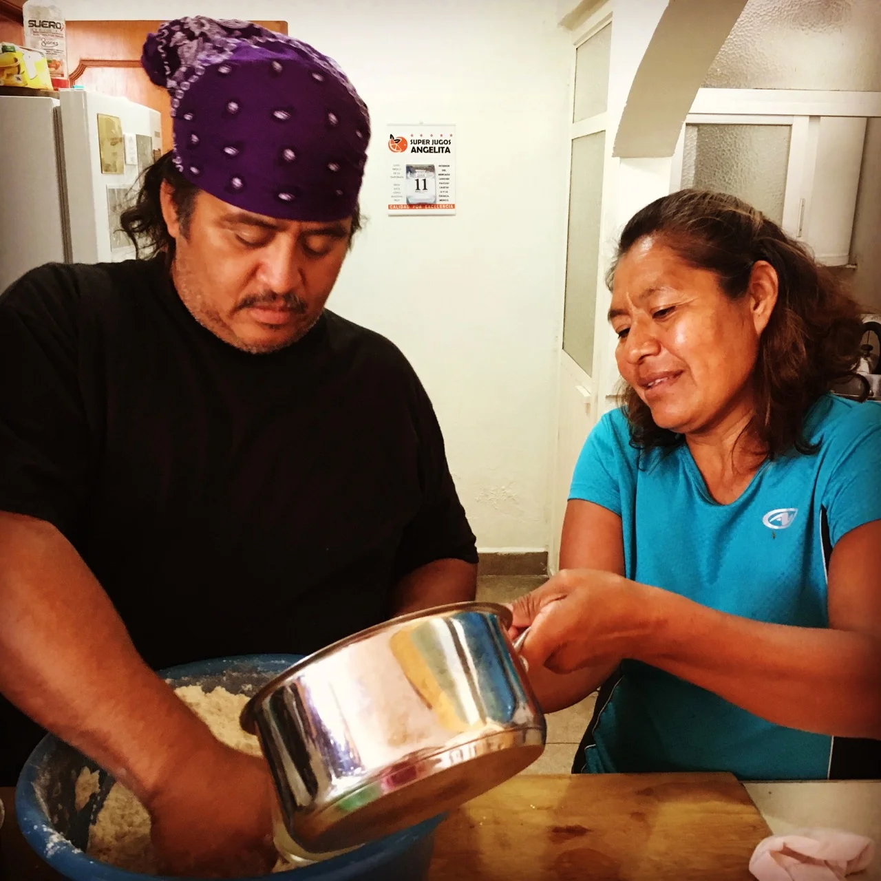 Vicky teaching Noel just how to mix the masa.