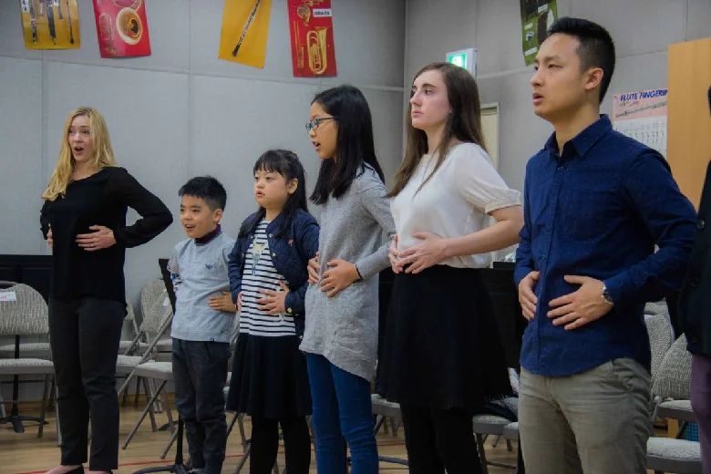 Students feel their diaphragm in action during the voice workshop
