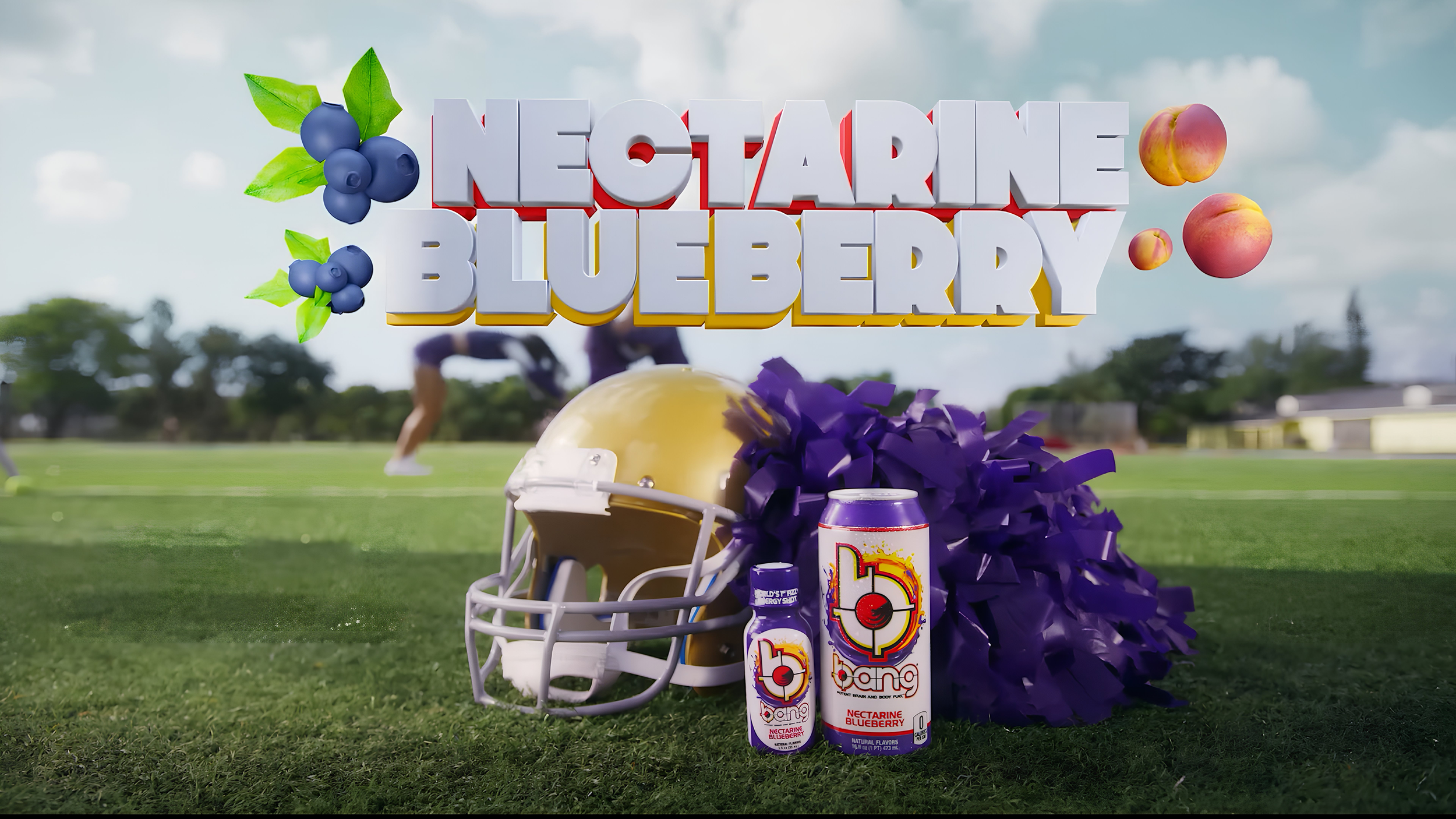 An American football helmet, purple pom-pom, energy drink cans, and blueberries on a grassy field. Large 3D text reads 'NECTARINE BLUEBERRY' with images of blueberries and peaches. The scene is outdoors under a partly cloudy sky with people in athletic clothing in the background.