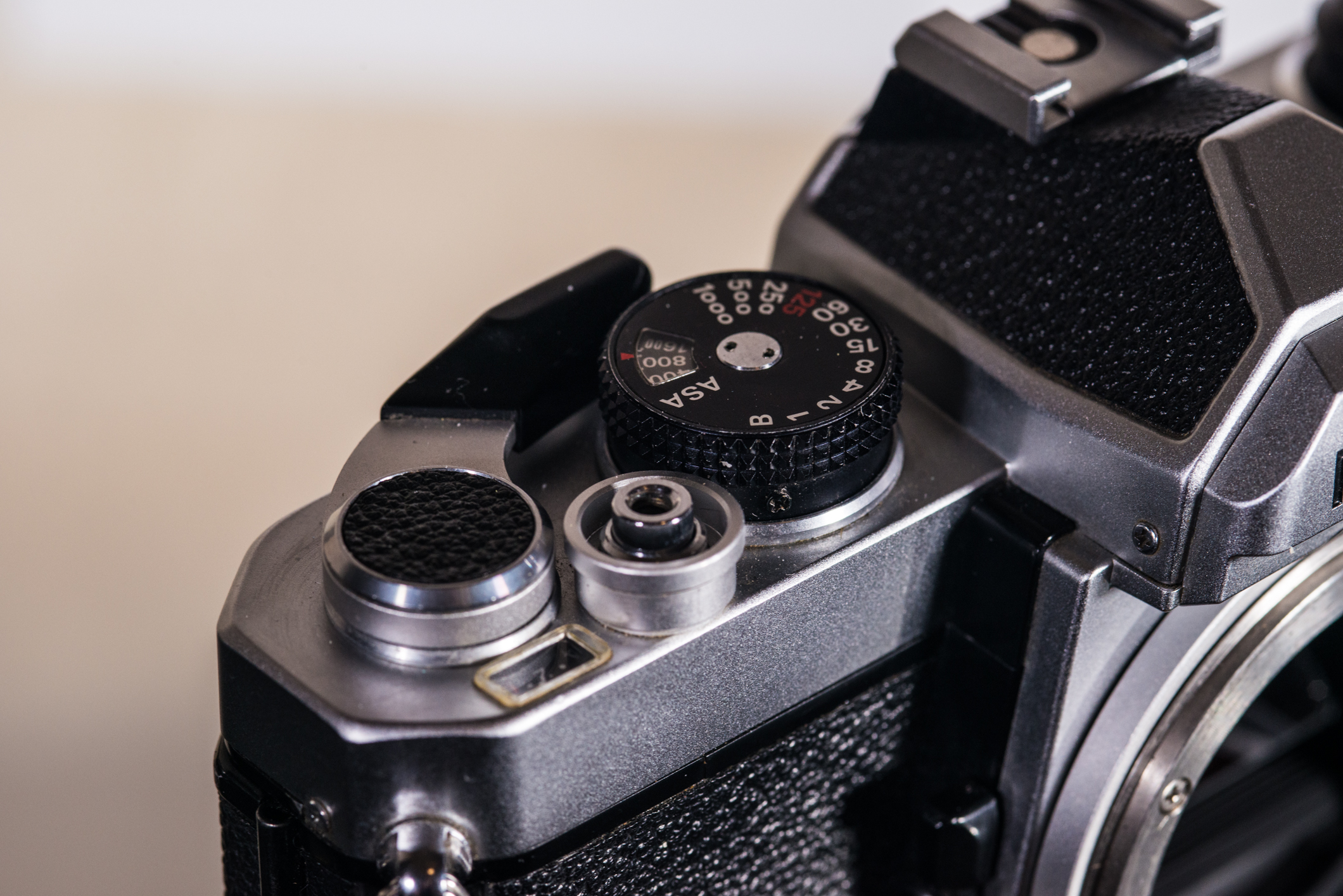 The FM's main controls. Flash X-sync, marked in red, is limited to 1/125. The film advance stopper is hidden behind the shutter speed dial.