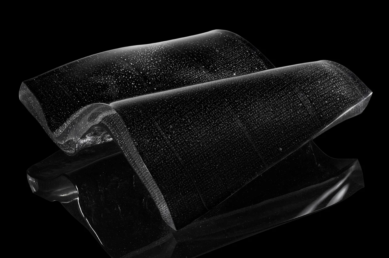 MATIÈRE NOIRE , 2009, 46x46x17 cm, Photo: didierlecoq.com La couleur noire s’impose pour les mystères qu’elle véhicule : matière noire, énergie noire... Par sa nature même le verre appelle une délimitation fluctuante, entre les formes et les apparences, entre le dedans et le dehors. L'univers, la lumière, l'espace et le temps sont sans limites, sans frontières, sinon mentales. Intuitivement, j'ai imaginé cette matière noire comme métaphore des limites de notre connaissance, et l'ondulation, le pli, comme métaphore du mouvement, de la dichotomie entre réalité et mystère : que savons-nous au juste ? The colour black is essential for the mysteries it conveys: dark matter, dark energy... By its very nature, glass calls for a fluctuating boundary, between shapes and appearances, between inside and outside. The universe, light, space and time are limitless, without borders, if not mental. Intuitively, I imagined this dark matter as a metaphor of the limits of our knowledge, and the undulation, the fold, as a metaphor of movement, of the dichotomy between reality and mystery: what exactly do we know?