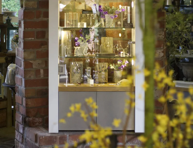 Cabinet under the old kiln displaying handmade, silver jewellery.