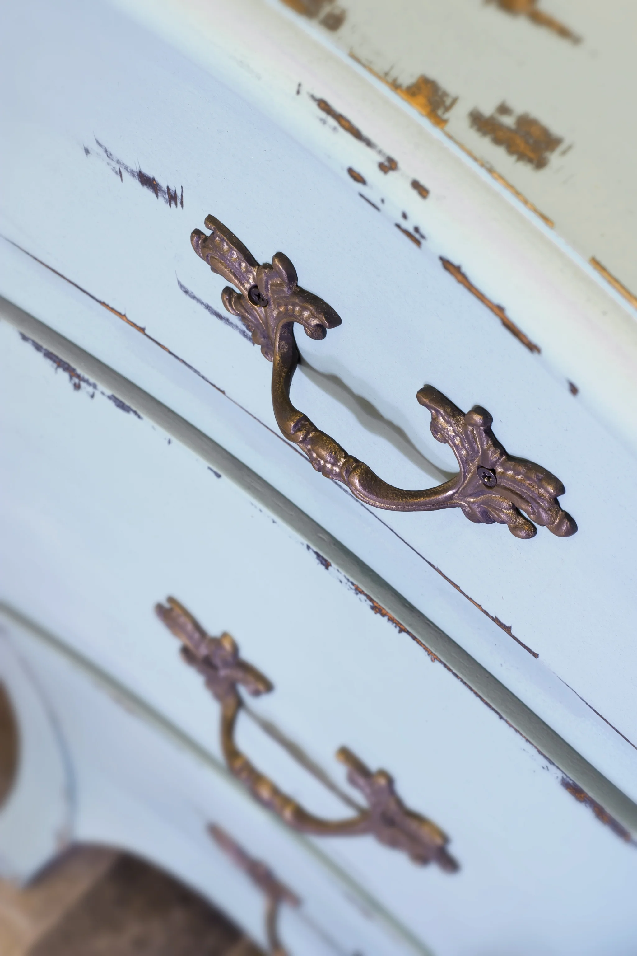 Vintage style, blue painted drawers with ornate metal handles.