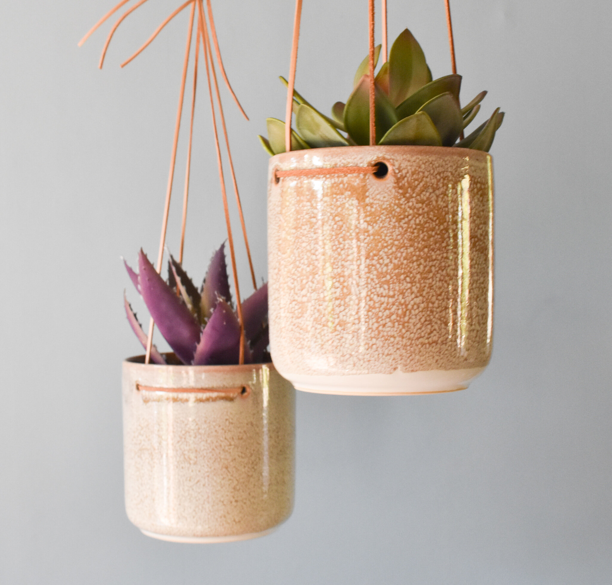 Mottled hanging ceramic planter on leather cord, by Broste