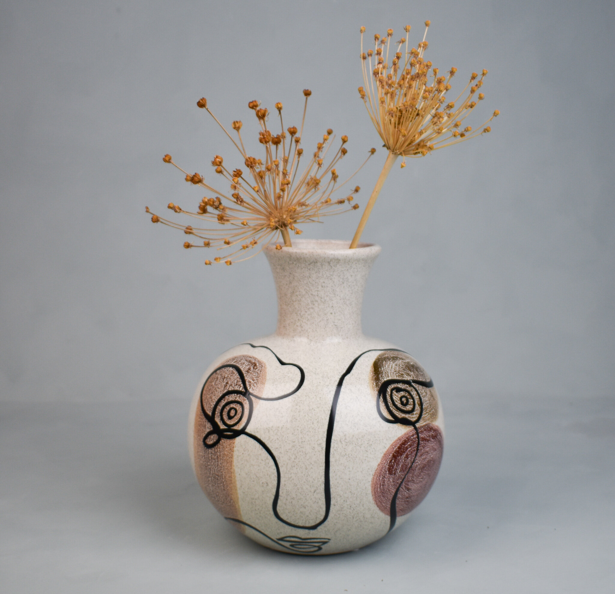 Abstract face design spherical stoneware vase, by Bloomingville