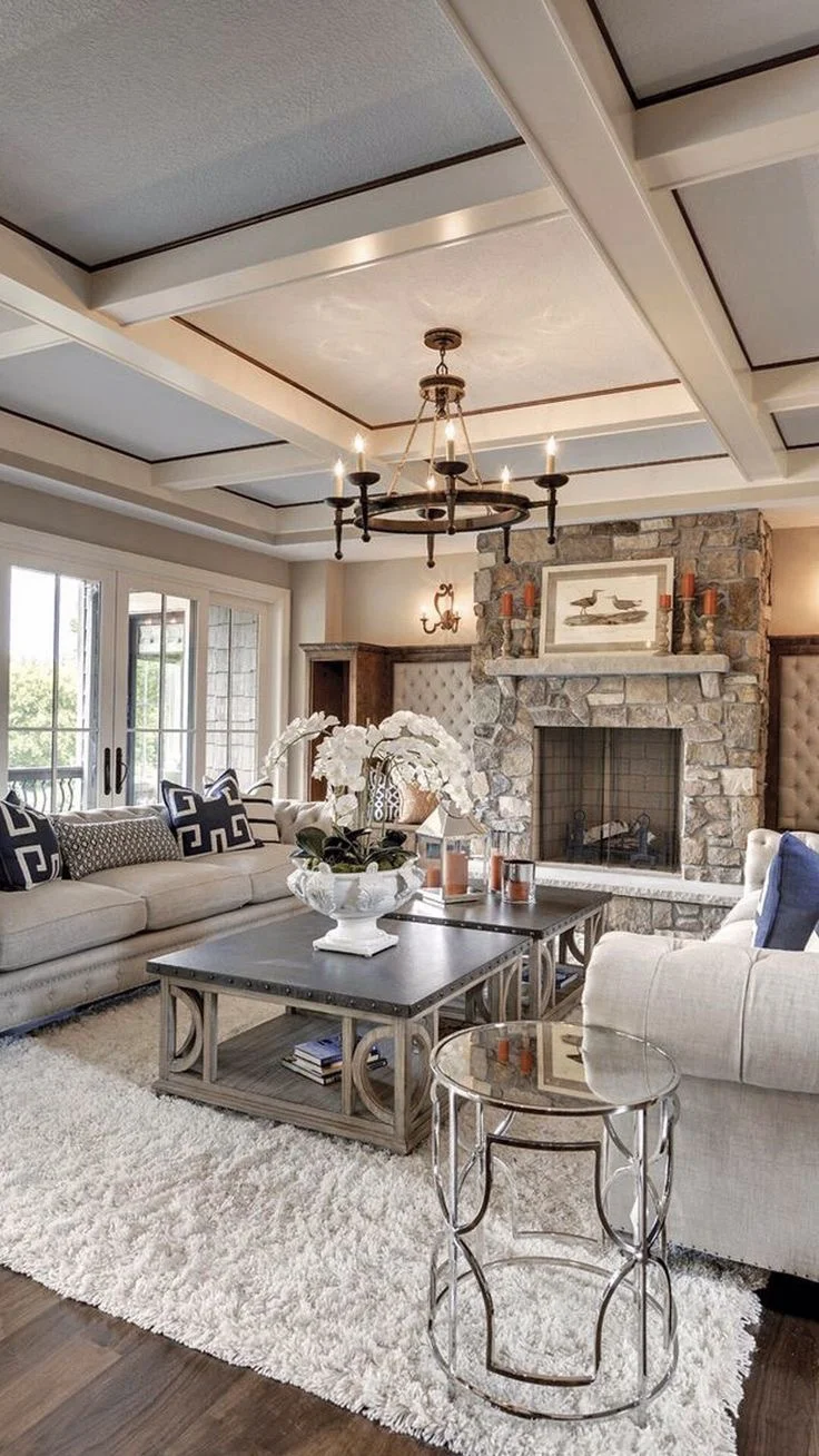 The wood paneled ceiling, chrome accent furniture, furry rug and stone fireplace stand out against the otherwise neutral palette. Courtesy of Pinterest