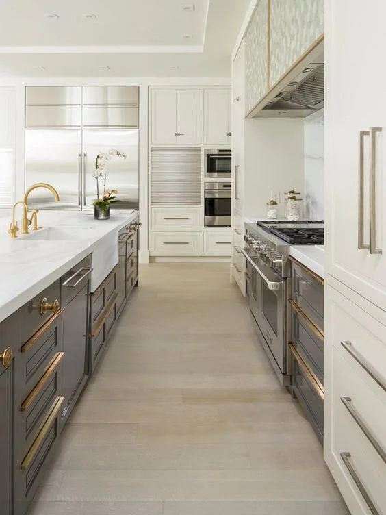 A beautiful blend of brass & stainless… The white cabinets and marble countertop tie together the brass hardware and cabinet pulls with the stainless appliances and lower grey cabinetry. (Courtesy of Pinterest)