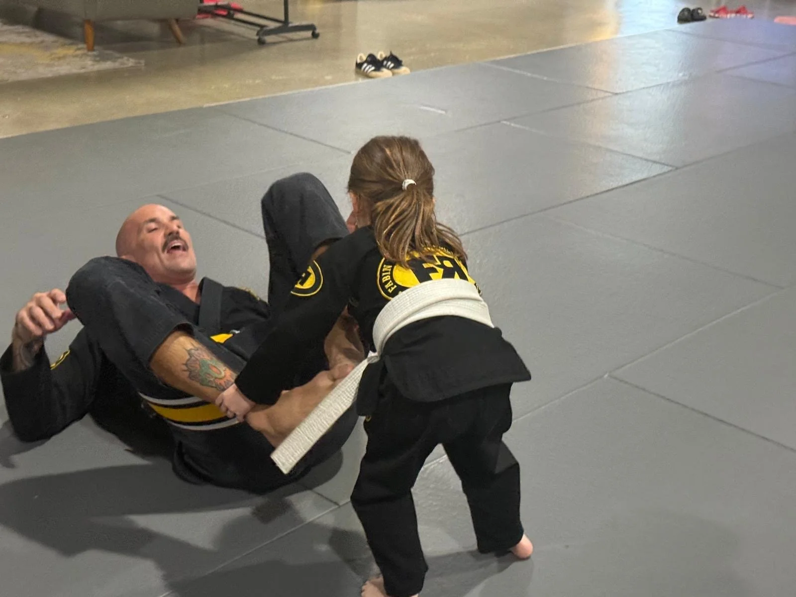 An instructor practicing jiu-jitsu with a young student at FRBJJ Lake Nona