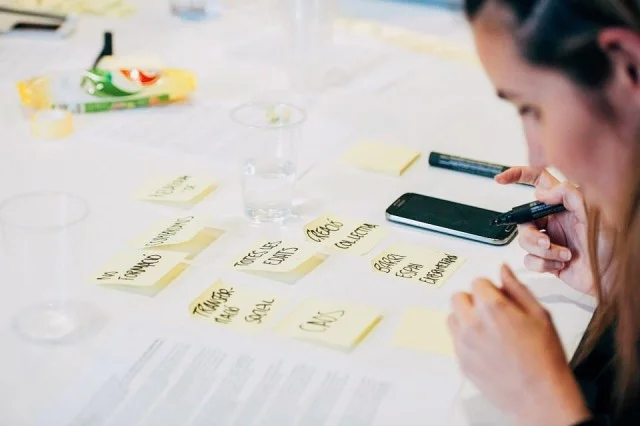 stock-photo-ideas-working-inspiration-young-woman-office-worker-writing-brainstorm-post-it-3da01ca7-2341-4a90-bffa-2ef77ac01937.jpg