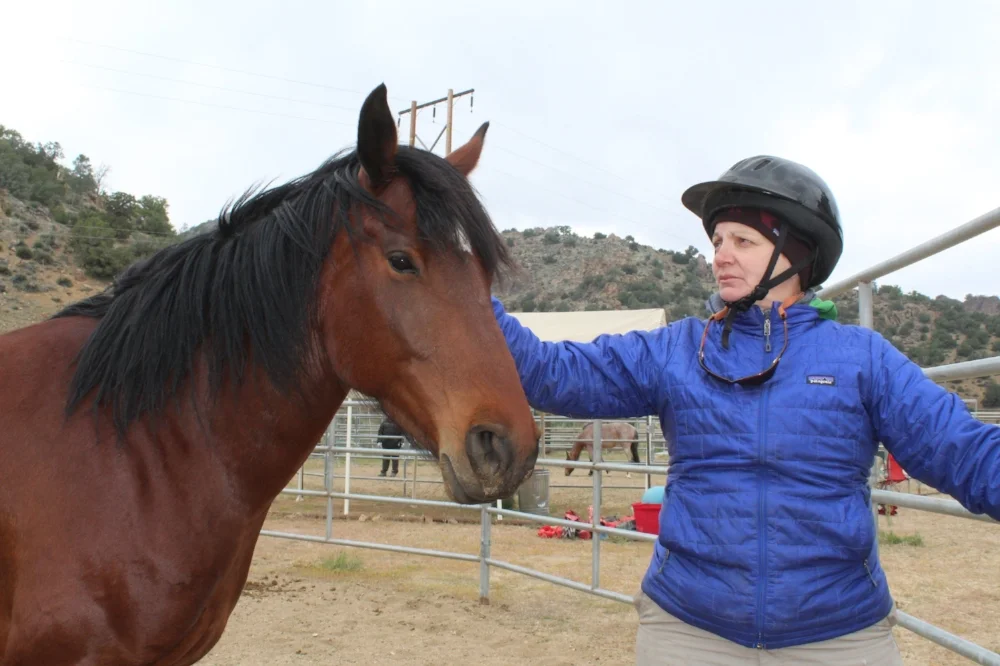 One of our veterans, Genee, with a wild mustang at Lifesavers Wild Horse Sanctuary. This was during the "Wild Horse Warriors" retreat sponsored by EET and Lifesavers with a group of 6 female veterans and 6 wild mustangs.