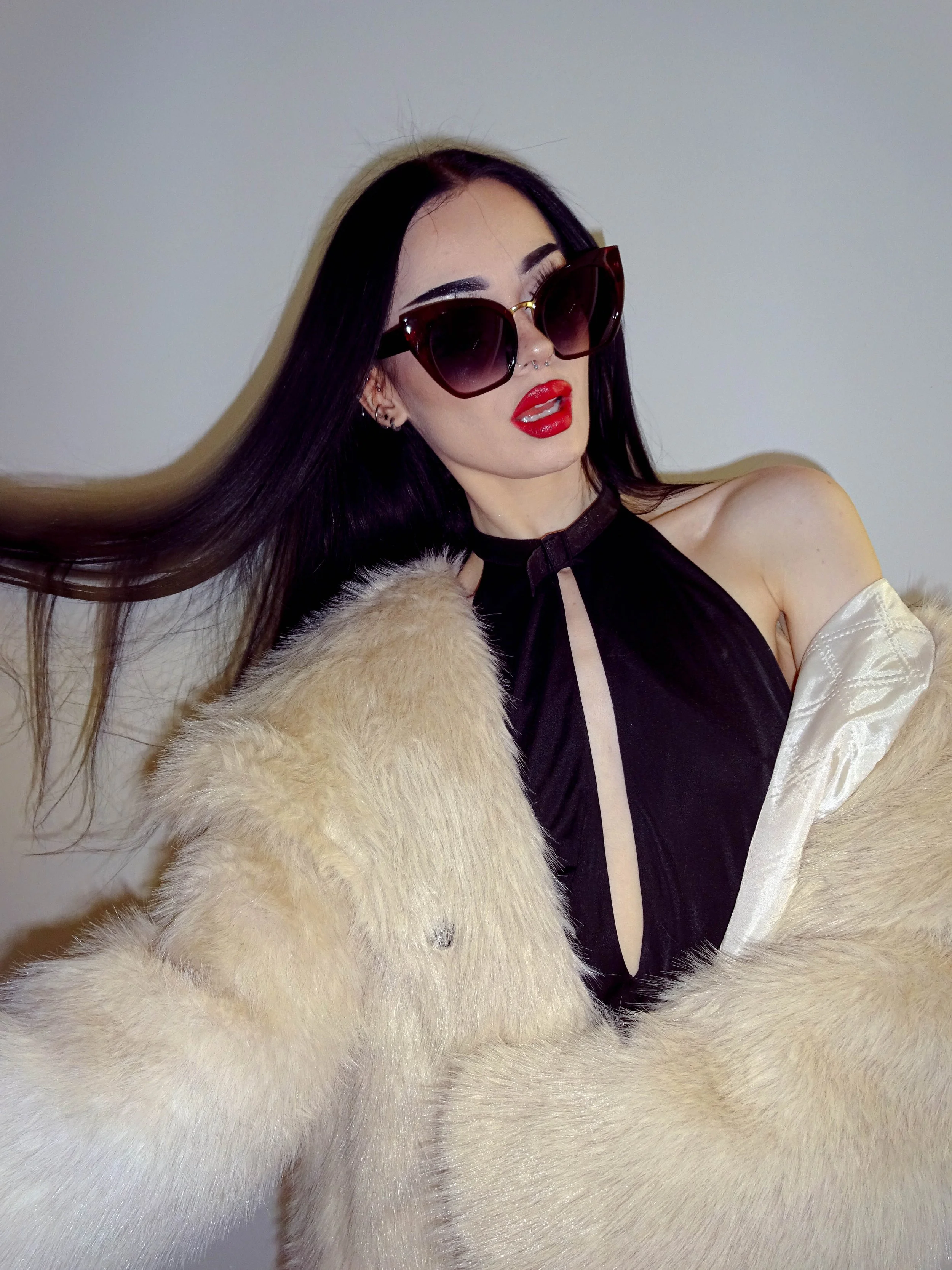 Fashion model wearing luxury sunglasses and a fur coat, photoshoot.