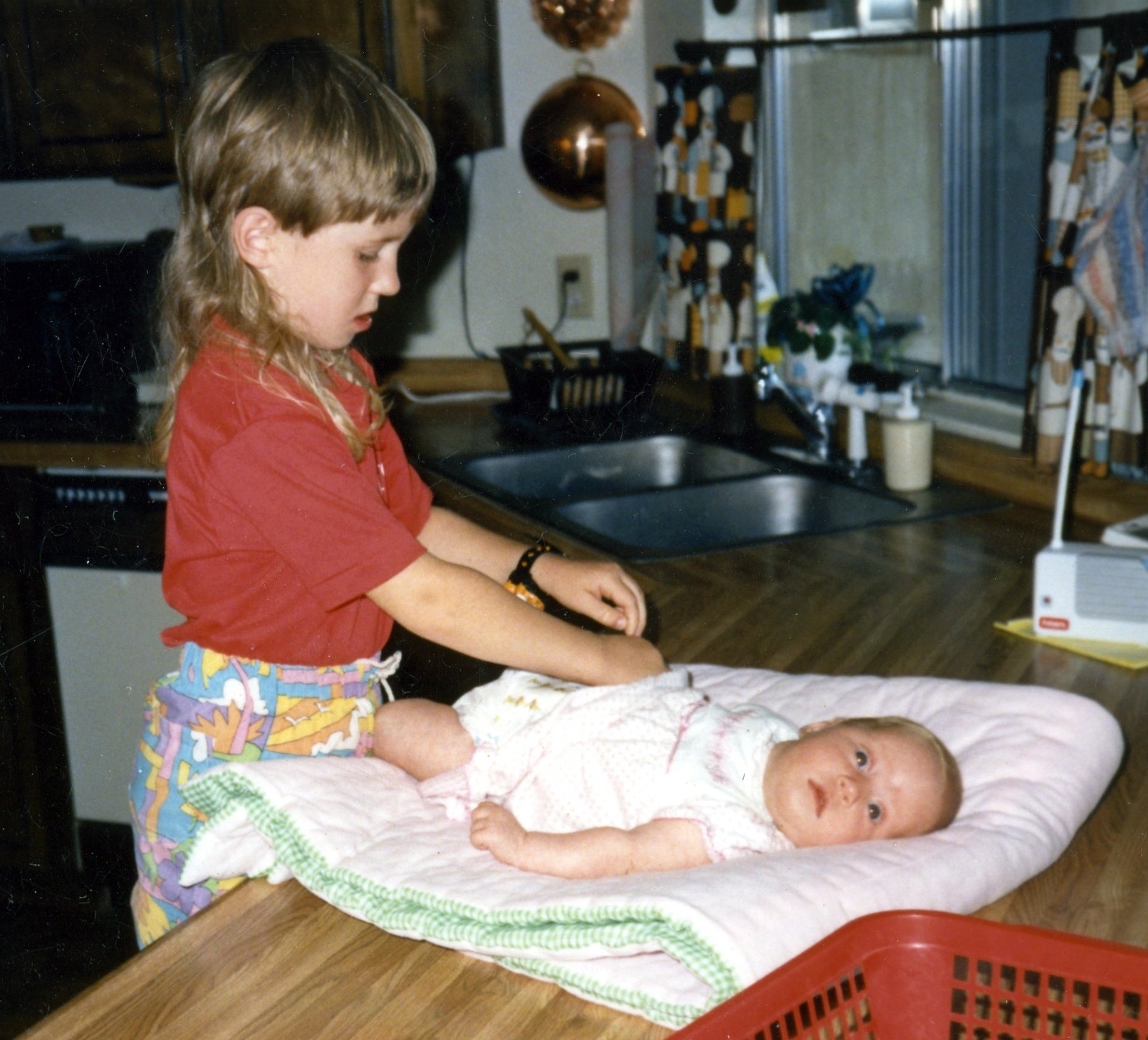 Big sister jessi learns to change baby sister jenn's diaper.