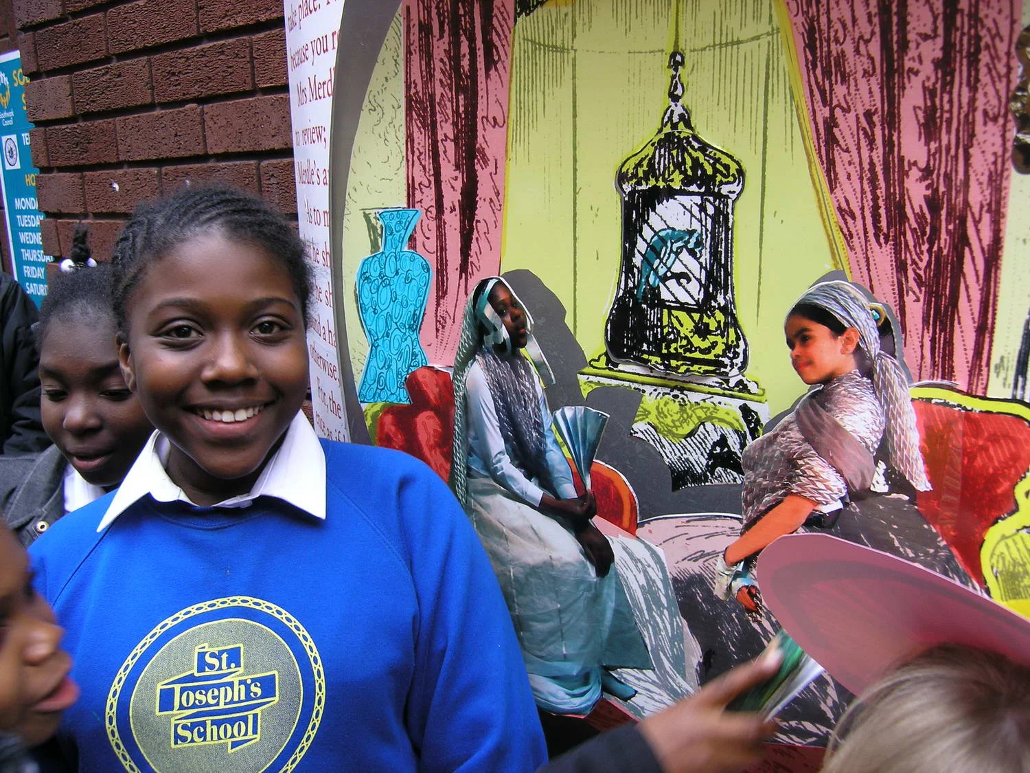 One of the pupils of St. Joseph’s School next to her image as Mrs Merdle. 