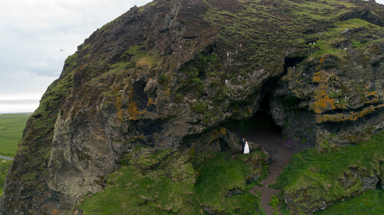 Iceland wedding photographer. Drone wedding photography of a couple in cave at South coast in Iceland.