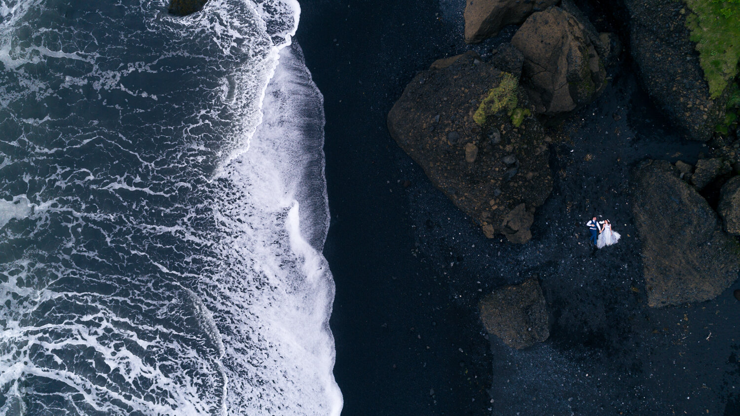 Iceland elopement photographer. Drone elopement photography of a couple on black beach in Vik in Iceland.