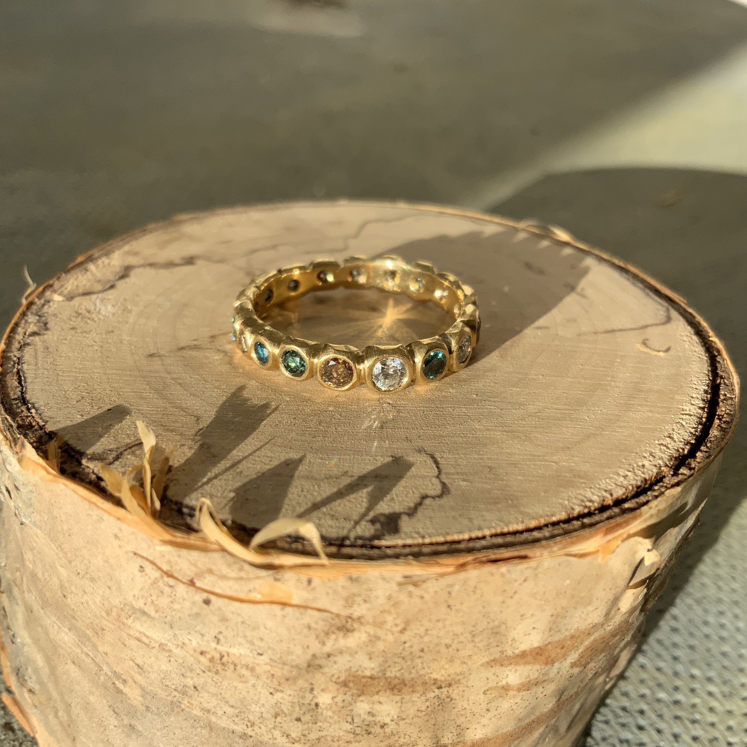 Designed from scratch with the customer and Erin. The exquisite diamonds were hand picked by Erin in teals, greens, browns and white.