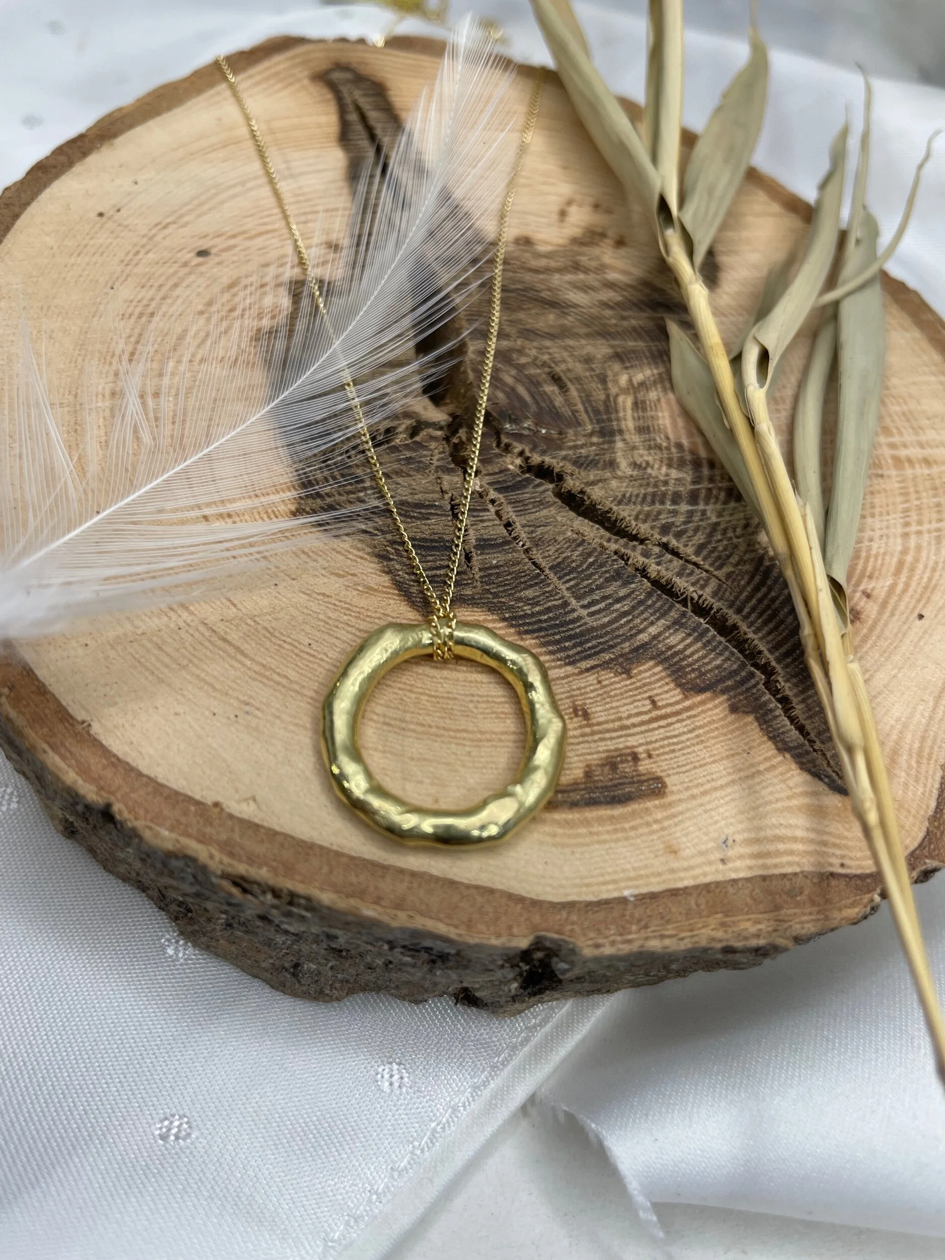 Organic molten circle necklace handmade in solid 18ct yellow gold by Erin Cox Jewellery in Topsham, Devon. Simple circle, one of a kind, pendant on curb chain.