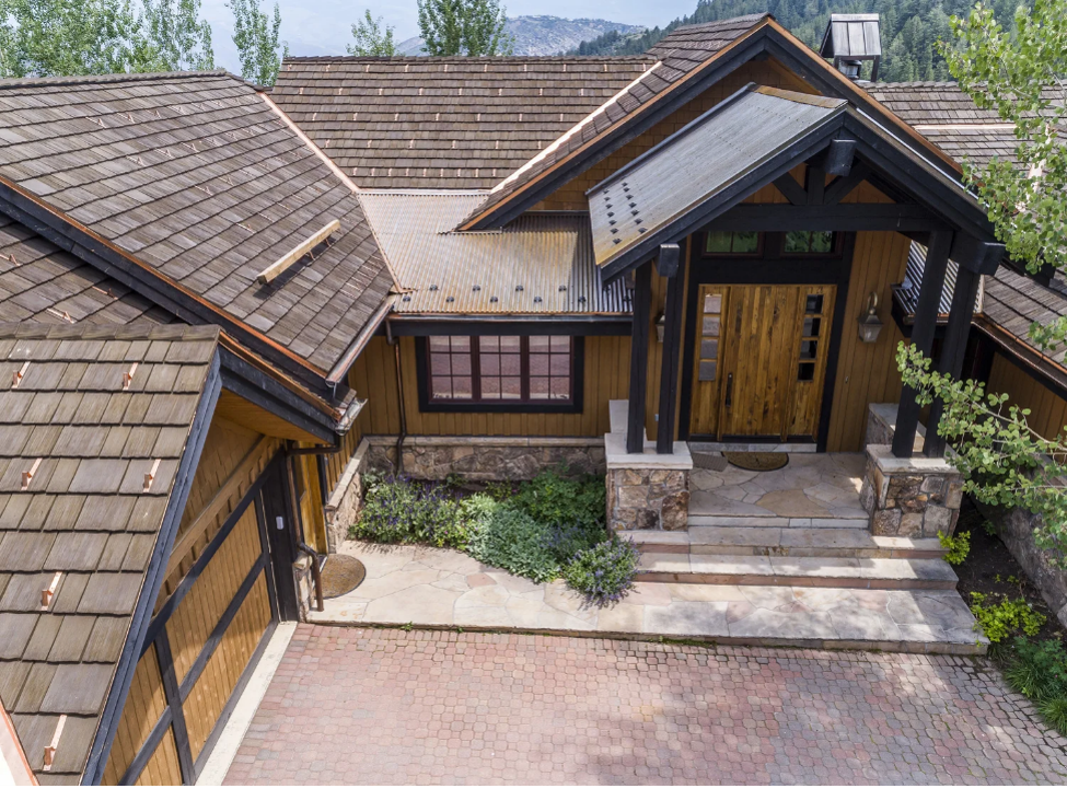 Mountain home with wood shake roof and metal accents.