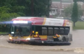 Rescuers pull people trapped on bus amid the six foot deep torrent.