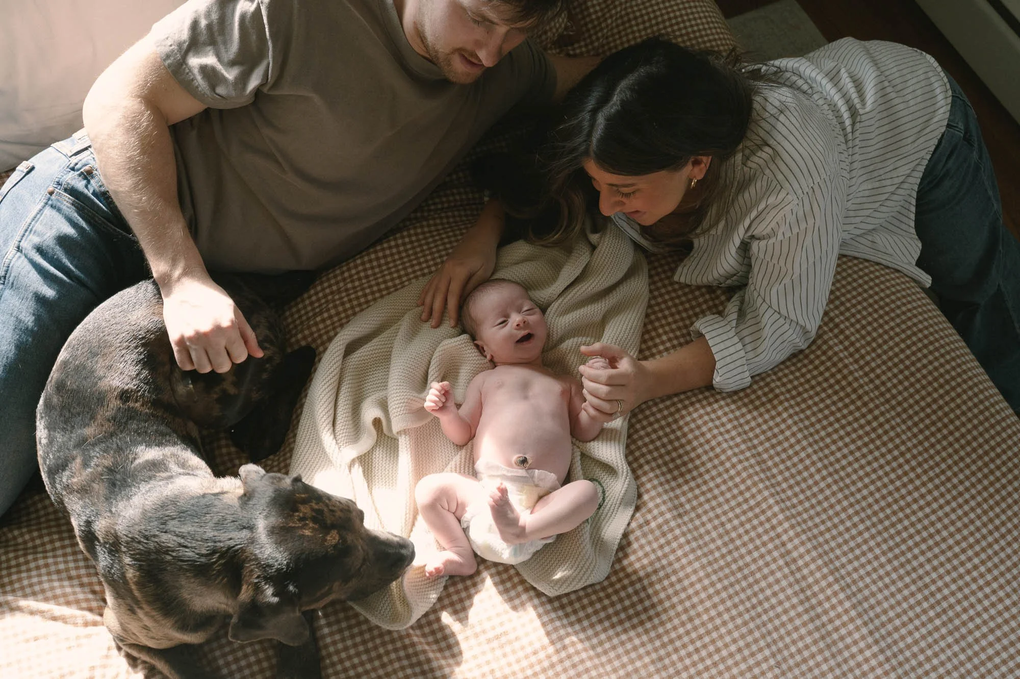 Family surrounds newborn baby during their in-home session in DC area