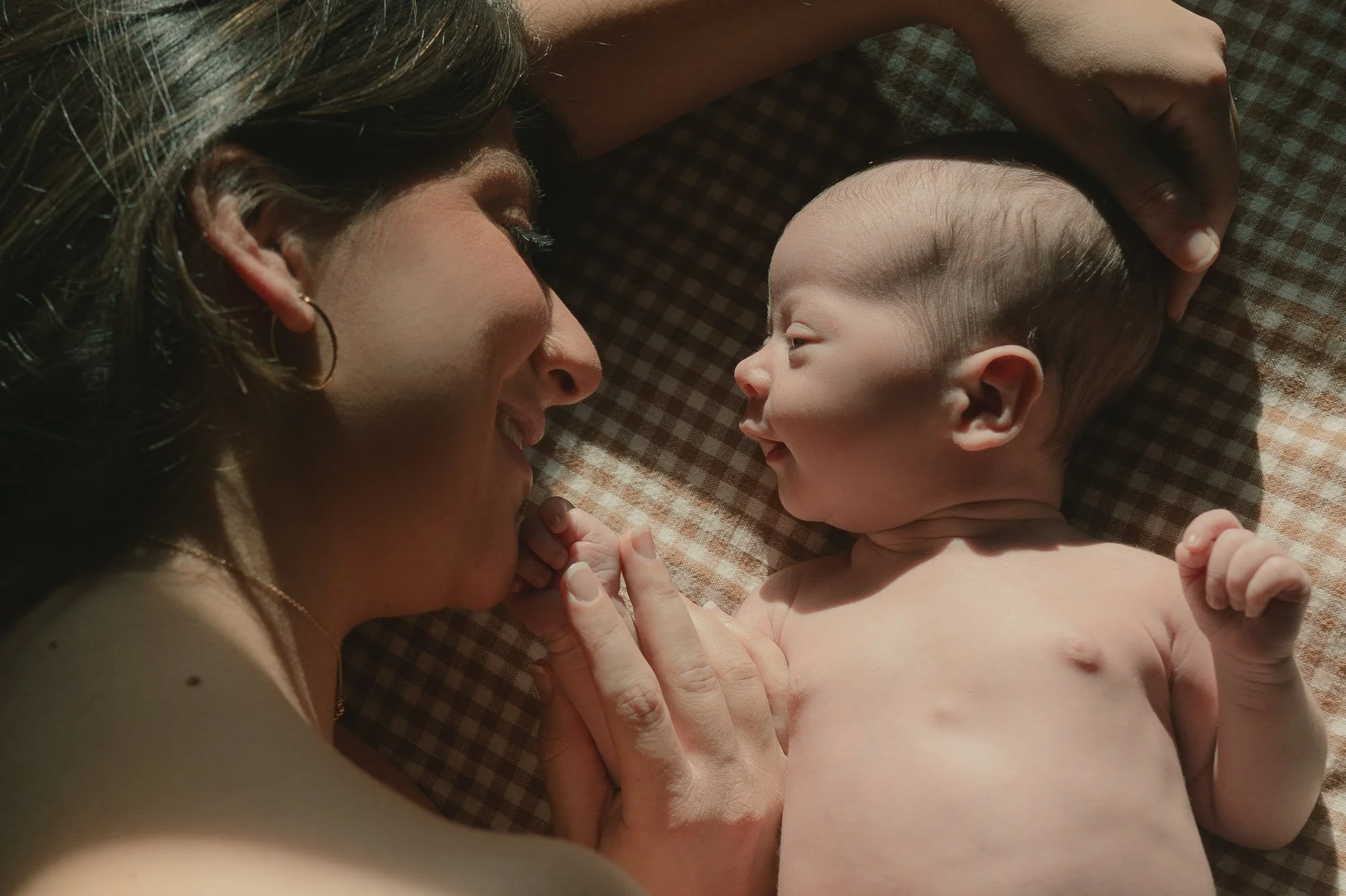 Mother with newborn baby during a motherhood in-home session in Potomac Maryland