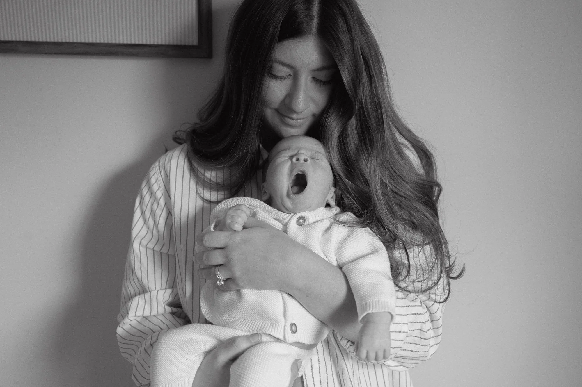 Mother with newborn baby during a motherhood in-home session in Potomac Maryland