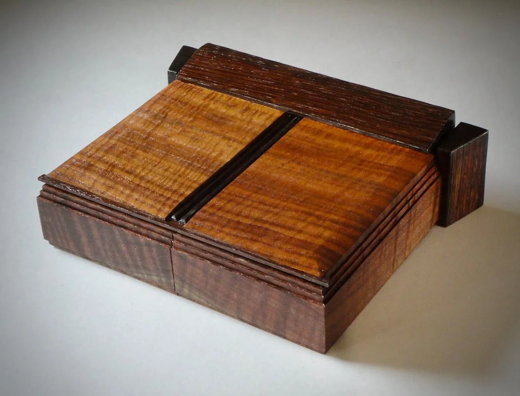   Primo Claro! , Matthew X. Curry, Figured walnut top and sides, wenge contrast detail, black leather, red strap and ebony liner, 11.5” x 3” x 9.5” $888 