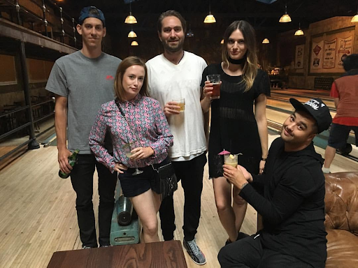 Group of friends relaxing at their bowling lane with cocktails while enjoying a night out at Highland Park Bowl.