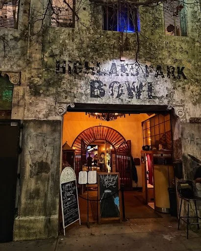 Exterior of Highland Park Bowl with its historic facade and warmly lit entrance at night.