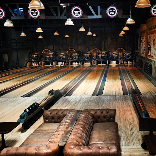 Historic bowling lane with vintage leather seating and warm lighting inside Highland Park Bowl.
