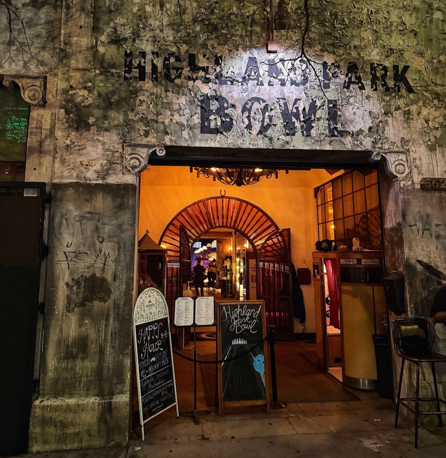 Entrance of Highland Park Bowl at night with rustic exterior and warm lighting.