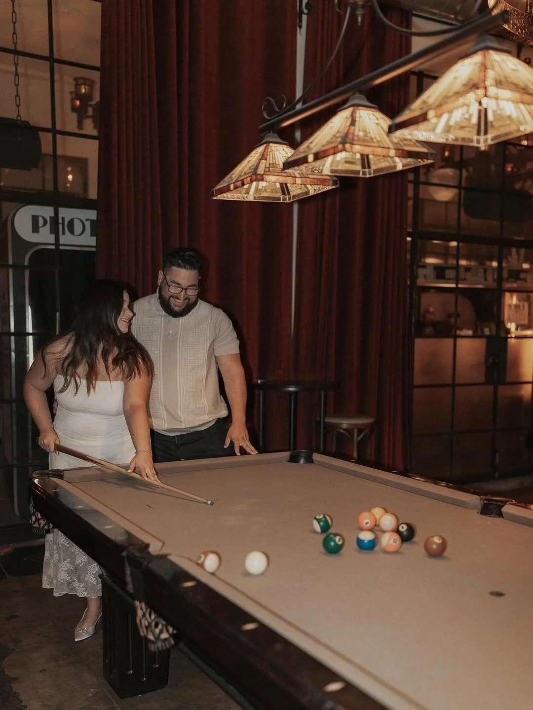 Couple smiling together beside a bowling lane during a date night at Highland Park Bowl.