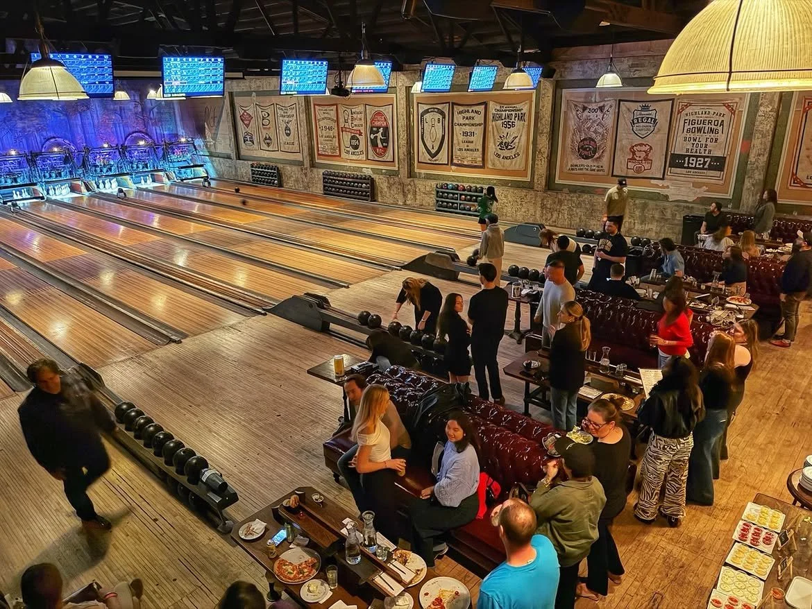Guests enjoying bowling, food, and drinks inside the lively Highland Park Bowl during a busy evening.