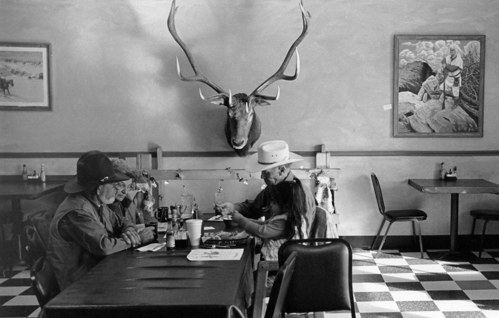 Family table, Aztec Restaurant, Aztec, New Mexico. Walking across the restaurant to look at a painting, I saw this family talking at the dinner table like we all did back in the day before cell phones.