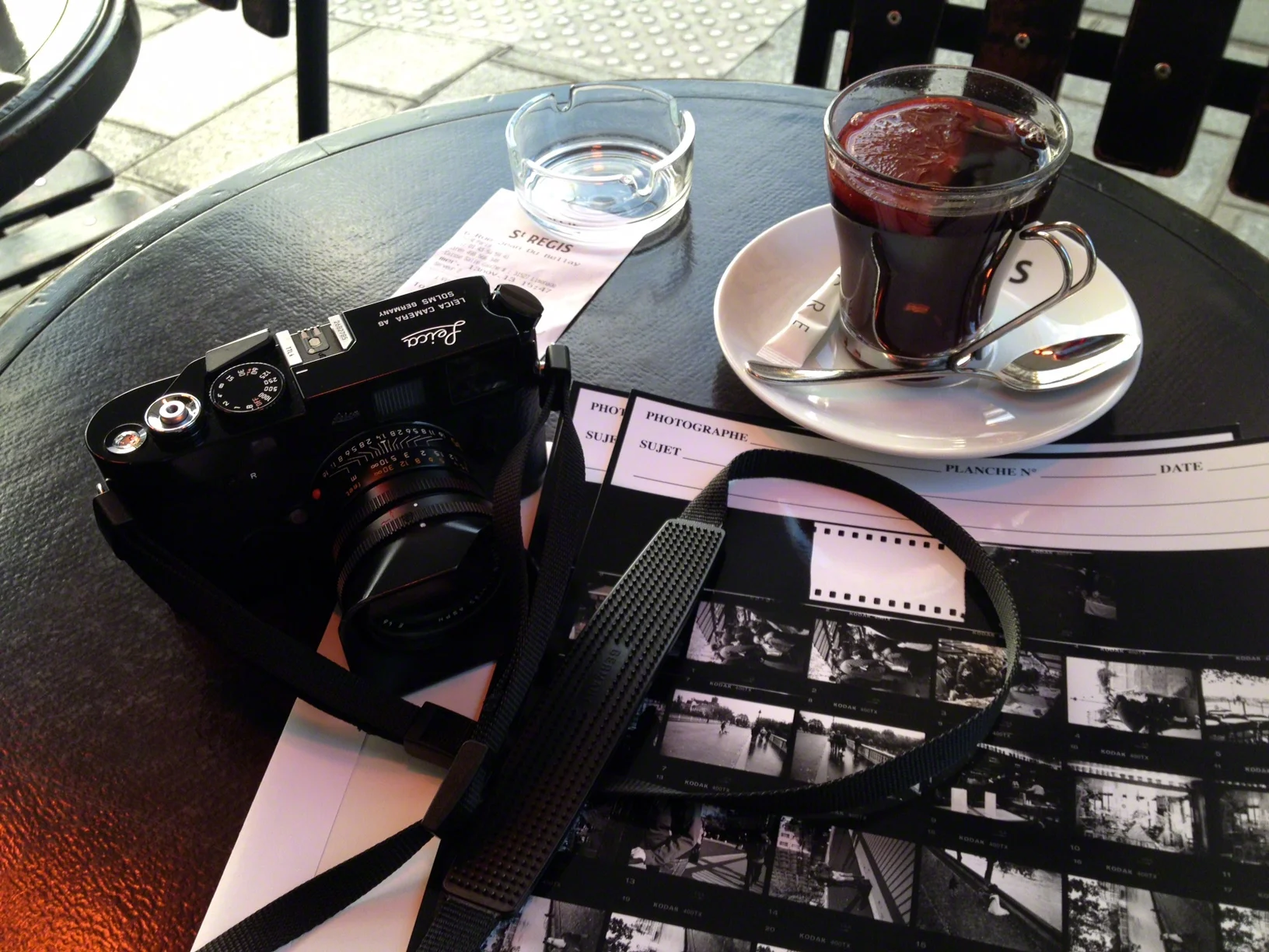 My Paris sojourns conclude with a glass of vin chaud (hot wine) while reviewing contact sheets of my film developed and printed by L’Atelier Publimod . A recipe for vin chaud : 1 bottle red wine, 4 cinnamon sticks, 1-1/2-inch by ½-inch piece of orange zest (white pith removed), 4 tablespoons granulated sugar, 2 cardamon pods, 5 whole cloves, 1/3 cup Cognac. Mix all the ingredients together in a large saucepan. Bring the mixture to just under a simmer over the lowest heat setting on the stovetop. Do not allow the wine to boil. The mulled wine is hot enough when the sugar has dissolved and pulling and lifting a spoon from the wine brings up steam. If desired, strain the spices from the wine by pouring it through a fine-mesh sieve or a cheesecloth-lined collander. Add 1-2 teaspoons of Cognac to a mug and ladle the mulled wine over it.