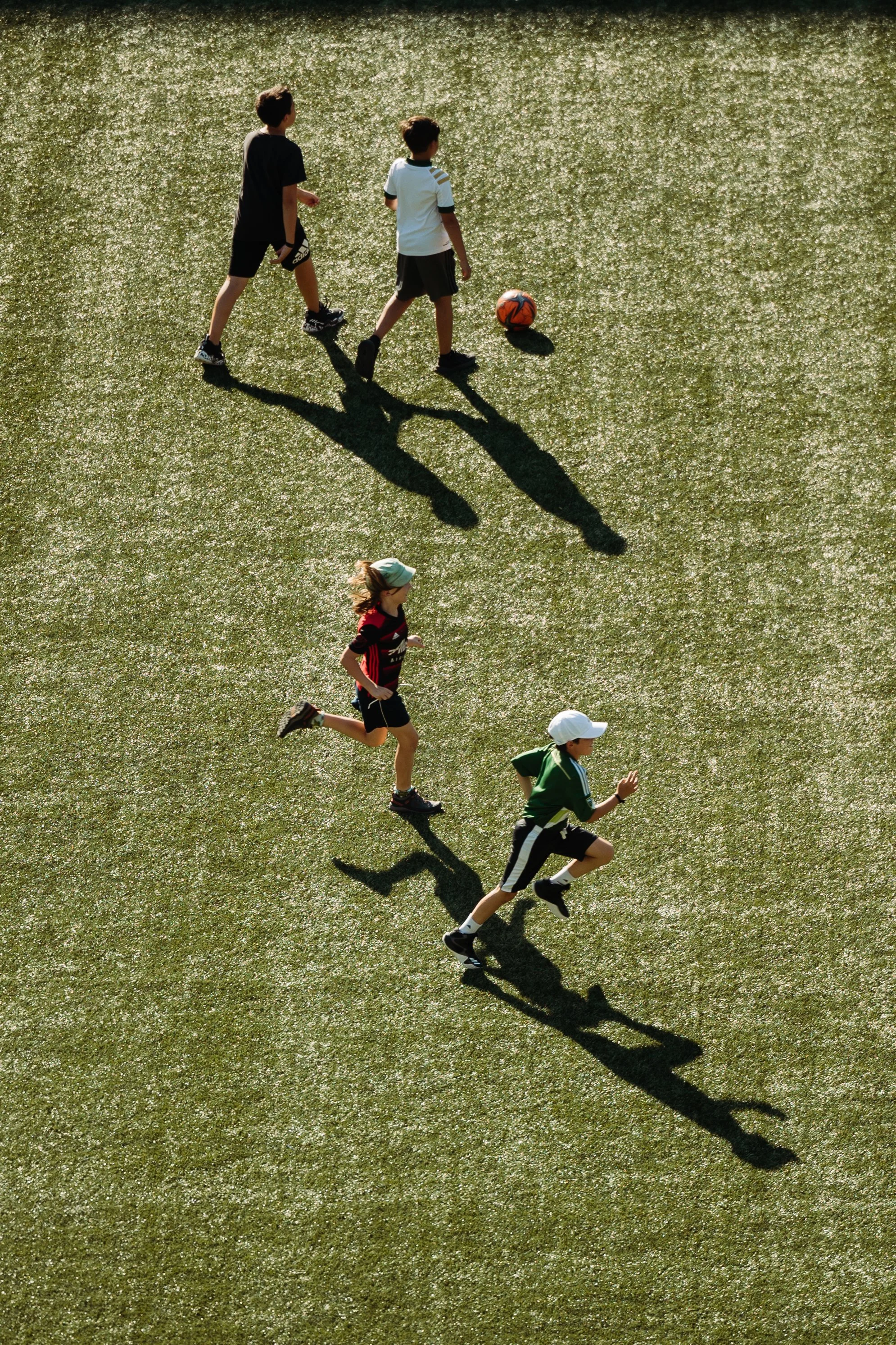 Kids kick soccer balls on the pitch at Lumen Field in Portland Oregon