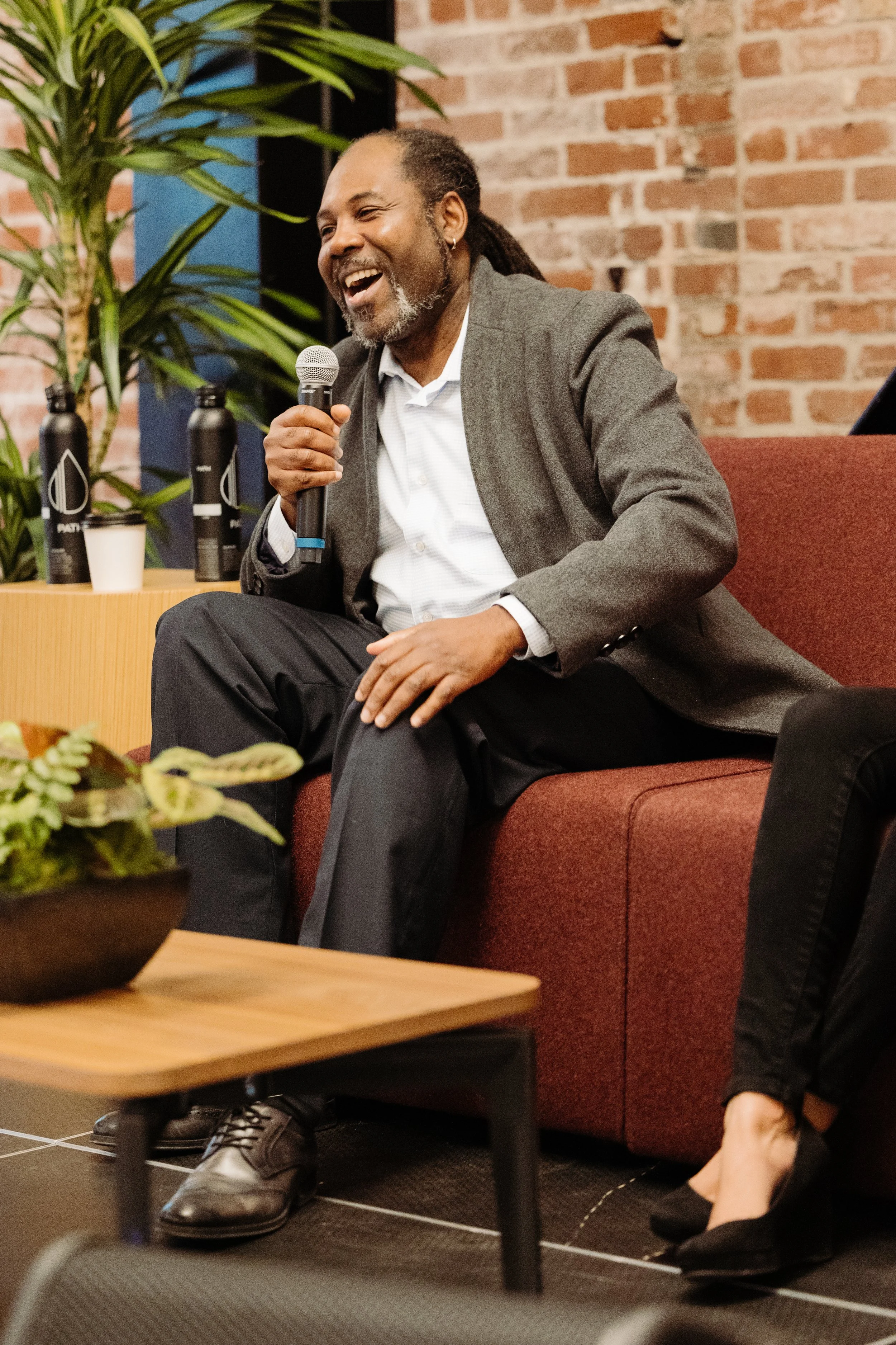 speaker laughs on stage at a conference in Portland Oregon
